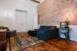 a living room with a blue couch and a brick wall at Old Town Central Apartment in Cluj-Napoca