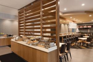 a restaurant with a counter with tables and chairs at SpringHill Suites by Marriott Houston Northwest in Houston