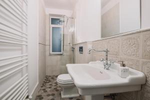 a white bathroom with a toilet and a sink at Old Town Central Apartment in Cluj-Napoca +48 photos
