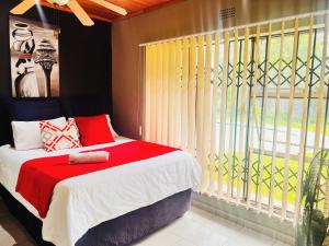 a bedroom with a bed and a large window at OGL Guesthouse in Vanderbijlpark