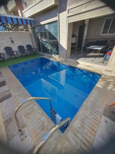 una piscina con un banco junto a una casa en la sublime, en Taghazout