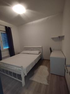 a bedroom with a bed and a table and a window at Apartman Marija in Grude