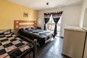 1 dormitorio con 2 camas y ventana en Palmeras Departamentos en Santa Teresita