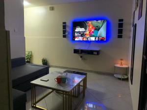 a living room with a tv on a wall at Rest N Ramble Hostel Near ADCB Metro Station in Dubai
