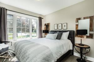 a bedroom with a bed and a large window at Our Special “Boutique” Quality Home in Old Towne in Niagara-on-the-Lake