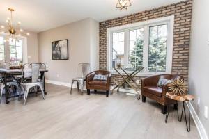 a dining room with a table and chairs and a brick wall at Our Special “Boutique” Quality Home in Old Towne in Niagara-on-the-Lake