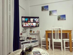 a living room with a table and a tv on the wall at Odore di Mare con Jacuzzi in Durrës