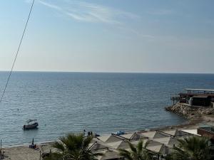 a boat in the water next to a beach at Odore di Mare con Jacuzzi in Durrës