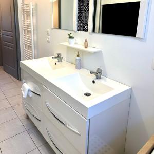 uma casa de banho branca com um lavatório e um espelho em Agréable villa proche du Château de Carcassonne ! em Cazilhac