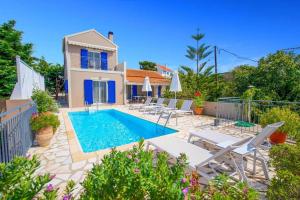 a villa with a swimming pool in front of a house at Joanna's Sunset Villa in Andipáta Erísou