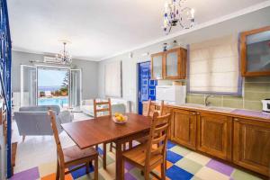 a kitchen with a wooden table and a dining room at Joanna's Sunset Villa in Andipáta Erísou