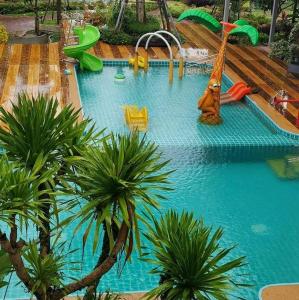 a pool with a water park with slides and palm trees at Mana-An Lake Hill Resort in Chiang Mai