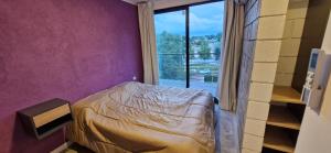 a bedroom with a bed and a large window at Vivisierras, Piso 3 frente al lago, centro Villa Carlos Paz, 2 dormitorios, 2 baños, pileta privada, premium in Villa Carlos Paz