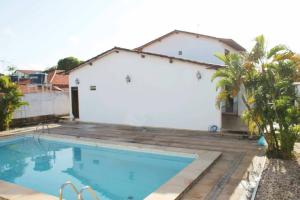 a house with a swimming pool next to a building at JF Studio Hotel in São Luís