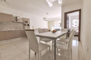 a kitchen and dining room with a table and chairs at Naxxar Gardens in Naxxar