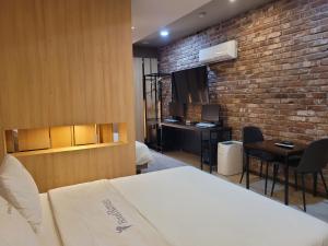 a room with a bed and a brick wall at Romio Motel in Gwangju