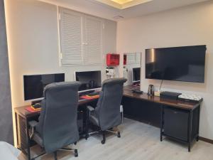 an office with a desk with two chairs and a monitor at Romio Motel in Gwangju