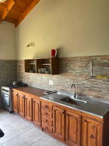 cocina con fregadero y fogones en Casas Pura Vida en Villa General Belgrano