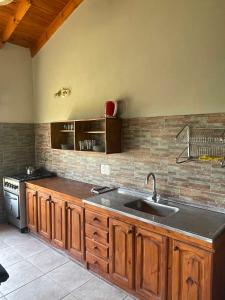 a kitchen with a sink and a stove at Casas Pura Vida in Villa General Belgrano