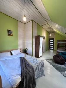 a bedroom with a large bed in a room with green walls at ЛемГора in Vorokhta