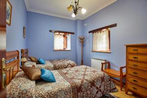 2 Betten in einem Schlafzimmer mit blauen Wänden in der Unterkunft Casa Rural Casa Capión in Villaviciosa