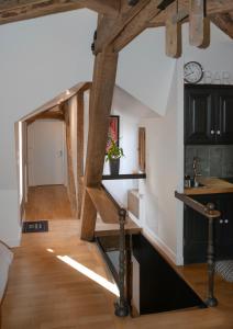 cocina y sala de estar con vigas de madera. en Loft dans le clocher face au chateau en Bonnelles
