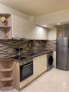 a kitchen with white cabinets and a stainless steel refrigerator at Lena in Sofia