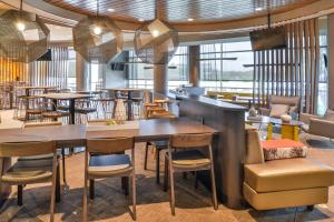 a restaurant with tables and chairs in a room at SpringHill Suites Ashburn Dulles North in Ashburn
