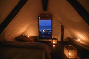 a attic room with two beds and a window at Narakan Cabo Polonio in Cabo Polonio
