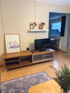 sala de estar con mesa y TV en Saunallinen rivitalokaksio Varkaudessa, en Varkaus