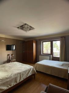 a hotel room with two beds and a window at Two sisters in Bakuriani