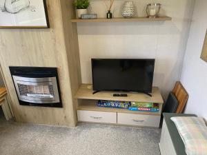 een flatscreen-tv op een stand in een kamer bij Nala Lodge in Knaresborough