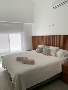 1 dormitorio con 1 cama grande y 2 toallas. en Playa Hermosa, Mistico, Surf, Bike, Hike, 4 Hab, Lagos, Familia, en Jacó