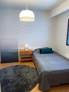 a bedroom with a bed and a table and a lamp at Saunallinen rivitalokaksio Varkaudessa in Varkaus