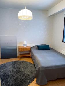 瓦爾考斯的住宿－Saunallinen rivitalokaksio Varkaudessa，一间卧室配有一张床、一张桌子和一盏灯