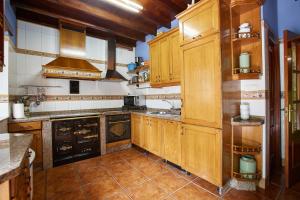 a large kitchen with wooden cabinets and appliances at Casa Rural Casa Capión in Villaviciosa