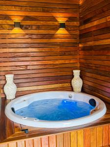 un jacuzzi dans une pièce en bois avec deux vases dans l'établissement Casa nova Itagua , há 3 minutos da Praia Grande, à Ubatuba 43 autres photos