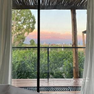 een kamer met een groot raam met uitzicht op een veld bij La Viñita Wine Lodge in San Carlos