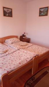 a bedroom with a bed and a nightstand with a bed sidx sidx at Maja Apartman in Igalo