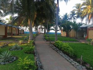 a walkway in front of a resort with palm trees at Casa Jaragua in Barra de Santiago