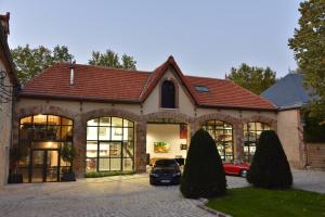 a house with a car parked in front of it at Loft dans le clocher face au chateau in Bonnelles