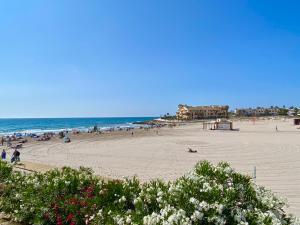 a beach with a lot of people and the ocean at La Zenia Boulevard & Beach House in Orihuela Costa