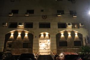 a building with two doors and two cars parked in front at Nour Hotel in Amman