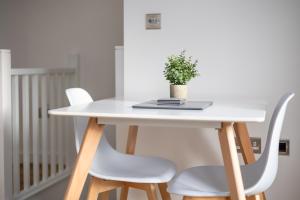 a white table with two chairs and a potted plant at Horsforth, Leeds - Parking, EV Supply, WiFi, Workspace, Self Check-in, En-suites, King Size Bed - Contractors, Families, Long Stays - Alt-Stay in Horsforth