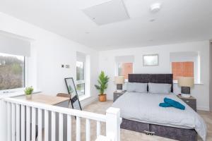 a white bedroom with a bed and a staircase at Leeds, Horsforth 2 Bed En suite - Off Road Parking, Self Check-in, EV Supply Equipment, Fast Wi-Fi - Families, Contractors, Long Stays in Horsforth