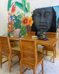 a table and chairs with a mural of a head at HOSTEL LA CASA DE PETRA in Santa Marta