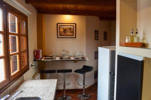 a kitchen with a bar with stools and a refrigerator at Catalina Apart in San Salvador de Jujuy