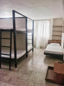 カリにあるRoof Hostelの二段ベッド2台とテーブルが備わる客室です。
