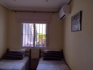 - 2 lits dans une chambre avec fenêtre dans l'établissement Al Andalus Resort, à Vera