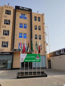 a group of flags in front of a building at العلي للشقق المخدومة Alalihotel in Hafr Al Baten